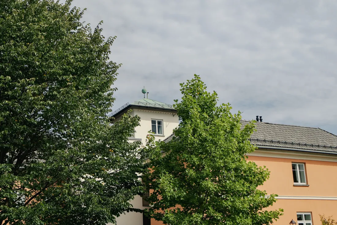 Fasaden på Chitra House mellom trærne