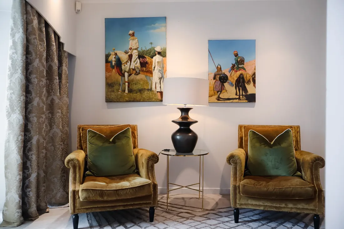 Armchairs beneath paintings in the hall