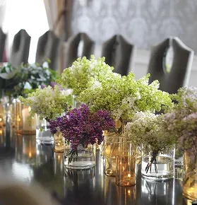 Blomsteroppsats med syrin og telys